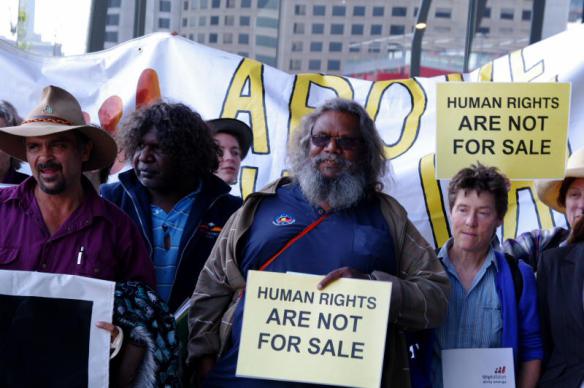 Elders, placards read Human Rights are not for sale 