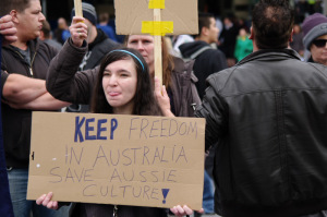 Young woman poking her tongue out - placard reads Keep Freedom in Australia Save Aussie Culture