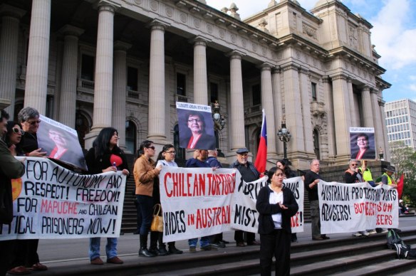 Banners lined up on steps of Parliament House, Marisol speaking