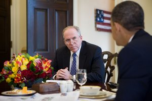 President Barack Obama receives information from John Brennan, assistant to the President for Homeland Security, about the plane crash in Austin, Tex., Feb. 18, 2010.