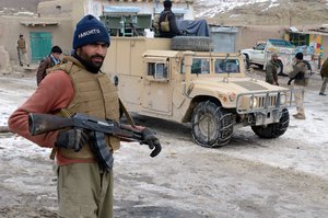 File - An Afghan Local Police (ALP) officer provides security while ALP and Afghan National Security Forces (ANSF) members search buildings during a presence patrol Jan. 12, 2014, in Spina village, Omnah district, Paktika province, Afghanistan