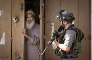 A Palestinian man closes his shop during clashes between Israeli troops and Palestinian protesters, in the West Bank town of al-Ram, north of Jerusalem, Thursday, Oct. 22, 2015.