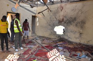 People inspect a damaged mosque following an explosion in Maiduguri, Nigeria, Friday, Oct. 23, 2015.