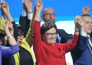 Polish Prime Minister and leader of the ruling Civic Platform Ewa Kopacz, center, holds hands with party members during their last rally ending the parliamentary elections campaign ahead of the Sunday voting, in Warsaw, Poland, Friday, Oct. 23, 2015.