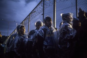 Migrants wait to register themselves outside a processing center in Moria village on the northeastern Greek island of Lesbos, Saturday, Oct. 24, 2015.