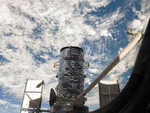 Hubble Gets a Lift. Atlantis' remote manipulator system arm lifts the Hubble Space Telescope from the cargo bay and is moments away from releasing the orbital observatory to start it on its way back home to observe the universe.