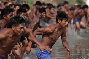 Indians from various ethnic groups run at the start of the men's swimming event during the World Indigenous Games in the Taguarussu River in Palmas, Brazil, Friday, Oct. 30, 2015.