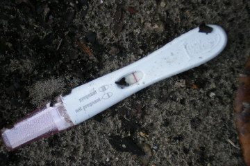 File: A discarded pregnancy test rests on a bed of dirt. (Flickr / Dominic Casario)