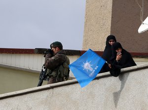 A special security force member surveys the area as supporters listen as Turkish Prime Minister Ahmet Davutoglu addresses a rally of his Justice and Development Party, or AKP, in Ankara, Turkey, Saturday, Oct. 31, 2015.