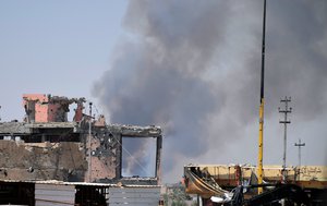 File - Smoke rises above a damaged building following a U.S.-led coalition airstrike against Islamic State group positions during a military operation to regain control of the eastern suburbs of Ramadi, in Anbar province, Iraq, Saturday, Aug. 15, 2015.