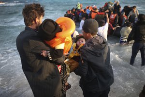 Refugees and migrants abort their effort on a dingy as they set out, trying to travel from the Turkish coast to the Greek island of Chios, near Cesme, Turkey, Saturday, Oct. 31, 2015.