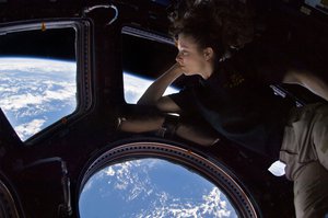 File - NASA astronaut Tracy Caldwell Dyson, an Expedition 24 flight engineer in 2010, took a moment during her space station mission to enjoy an unmatched view of home through a window in the Cupola of the International Space Station, the brilliant blue and white part of Earth glowing against the blackness of space.