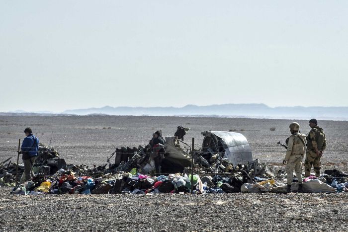 Egyptian army soldiers stand guard next to debris and belongings of passengers of the Kogalymavia airlines plane.