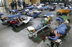 Refugees rest in their beds at a registration point for migrants and refugees in Neu Isenburg, Germany, Friday, Sept. 11, 2015.