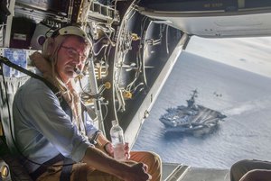 The USS Theodore Roosevelt can be seen in the background as Secretary of Defense Ash Carter flies in a V-22 Osprey after visiting the aircraft carrier with Malaysian Minister of Defense Hishammuddin Hussein Nov. 5, 2015.