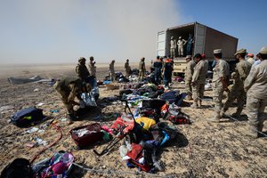 In this Monday, Nov. 2, 2015 file photo provided by the Russian Ministry for Emergency Situations, Egyptian soldiers collect personal belongings of plane crash victims at the crash site of a passenger plane bound for St. Petersburg in Russia that crashed in Hassana, Egypt's Sinai Peninsula.