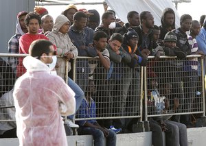 Migrants wait to disembark from the Iceland Coast Guard vessel Tyr, at the Messina harbor, Sicily, southern Italy, Wednesday, May 6, 2015.