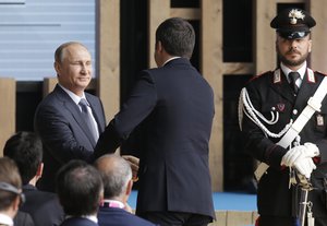 Russian President Vladimir Putin, left, shakes hands with Italian Premier Matteo Renzi, center, back to the camera, at the Russian pavilion at the 2015 Expo in Rho, near Milan, Italy, Wednesday, June 10, 2015.