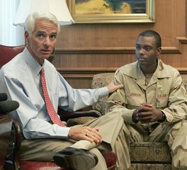 Florida Gov. Charlie Crist, left, talks with Senior Airman David Johnson about their connection to the Rosewood Massacre in 1923, Tuesday, March 20, 2007, in Tallahassee, Fla.