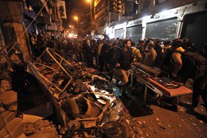 Lebanese army and civilians gather near the site of a twin suicide attack in Burj al-Barajneh, southern Beirut, Lebanon, Thursday, Nov. 12, 2015 that struck a Shiite suburb killing and wounding dozens, according to a Lebanese official.