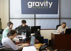 Sales representatives work Wednesday, April 15, 2015, at Gravity Payments, a credit card payment processor based in Seattle.