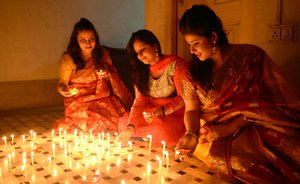 Indian women light candles to celebrate the Diwali Festival in Kolkata, India, on Wednesday 11 November 2015