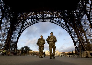 French soldiers patrol at the Eiffel Tower which remained closed on the first of three days of national mourning in Paris, Sunday, Nov. 15, 2015.