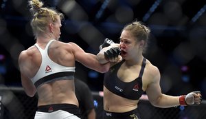 Holly Holm, left, and Ronda Rousey exchange their punches during their UFC 193 bantamweight title fight in Melbourne, Australia, Sunday, Nov. 15, 2015.