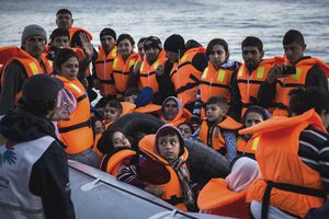 Syrian refugees disembark on the Greek island of Lesbos after crossing the Aegean sea on a dinghy from the Turkish coast, Saturday, Nov. 14, 2015.