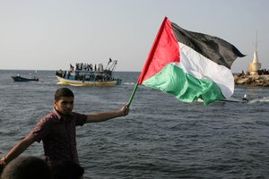 File - Palestinians fly flags to show their support for a flotilla attempting to reach Gaza, in the port of Gaza City, July 7, 2011. A previous flotilla in 2010, organized by the Free Gaza Movement, resulted in the deaths of 9 activists following an Israeli raid.