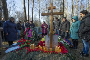 Maria, center, the mother of Alexei Alekseyev, one of the plane crash victims, stands with others, during his funeral at Bogoslovskoye cemetery in St. Petersburg, Russia, Thursday, Nov. 5, 2015.