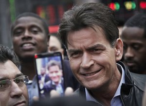 In this Monday, Jan. 14, 2013, file photo, actor Charlie Sheen is mobbed for autographs and photos as he makes his way through Times Square in New York. In an interview Tuesday, Nov. 17, 2015, on NBC's "Today," Sheen said he tested positive for the virus that causes AIDS.