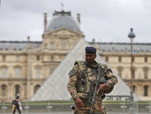 A soldier patrols in the courtyard of the Louvre Museum in Paris, Tuesday, Nov. 17, 2015.