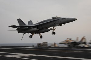 File - An F/A-18C Hornet assigned to the Thunderbolts of Marine Strike Fighter Squadron 251 lands on the flight deck of the aircraft carrier USS Theodore Roosevelt. Theodore Roosevelt is deployed in the U.S. 5th Fleet area of operations supporting Operation Inherent Resolve, involving strike operations in Iraq and Syria.