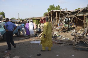 People gather at the site of a suicide bomb attack at a market in Maiduguri, Nigeria