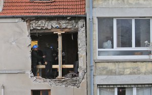 People work inside the damaged building of Wednesday's raid on an apartment in the Paris suburb of Saint-Denis, Thursday Nov.19, 2015.