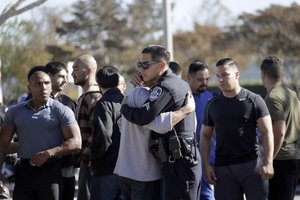 Unidentified police officers react as the Los Angeles County Coroner transports the body of Downey police Officer Ricardo "Ricky" Galvez in Downey, Calif., on Thursday, Nov. 19, 2015.