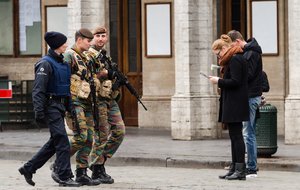 Belgian Army soldiers and a police officer patrol in the Grand Place in the center of Brussels on Friday, Nov. 20, 2015.