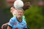 Amy Harrison of Sydney FC heads the ball away under pressure from Nicole Begg of United.