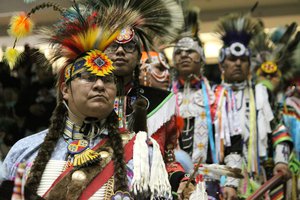 In this April 24, 2015, file photo, Native American and indigenous dancers wait their turn to join the procession during the grand entrance at the 32nd annual Gathering of Nations in Albuquerque N.M.