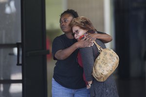 Two women embrace at a community center where family members are gathering to pick up survivors after a shooting rampage that killed multiple people and wounded others at a social services center in San Bernardino, Calif., Wednesday, Dec. 2, 2015.