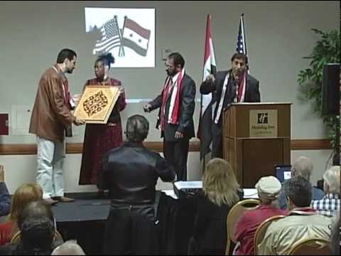 Syrian artist Sam Hassan presenting a gift to Congresswoman Cynthia McKinney at the forum on Syria