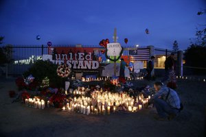 People pay respects at a makeshift memorial honoring the victims of Wednesday's shooting rampage, Saturday, Dec. 5, 2015, in San Bernardino, Calif.