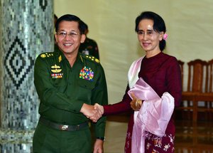 Opposition leader Aung San Suu Kyi, right, and Myanmar's Gen. Min Aung Hlaing, the military commander-in-chief, shake hands during their meeting Wednesday, Dec. 2, 2015, in Naypyitaw, Myanmar.