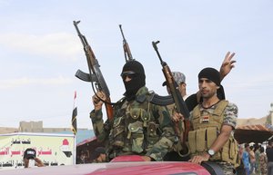 File - Sunni volunteer fighters parade as they prepare to support Iraqi security forces in liberating the city of Ramadi from Islamic State group militants, in Khalidiya, 60 miles (100 kilometers) west of Baghdad, Iraq, Saturday, Oct. 10, 2015.