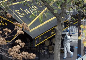 An investigator works outside the Bataclan concert hall, Saturday, Nov. 14, 2015 in Paris.