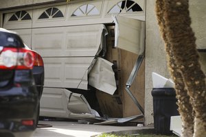 A garage door of Enrique Marquez's home is seen broken in a recent FBI raid, Wednesday, Dec. 9, 2015, in Riverside, Calif.