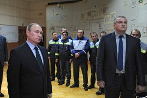 In this photo taken Wednesday, Dec. 2, 2015, Russian President Vladimir Putin, left, and Crimean leader Sergei Aksyonov, right, attend the inauguration of electricity connection with the Russian mainland in Simferopol, Crimea.