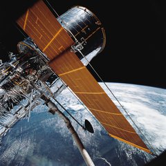 File - In this April 25, 1990 photograph taken with a handheld Hasselblad camera, most of the giant Hubble Space Telescope can be seen as it is suspended in space by Discovery's Remote Manipulator System (RMS) following the deployment of part of its solar panels and antennae. This was among the first photos NASA released on April 30 from the five-day STS-31 mission.