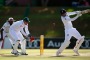 Joe Root of England hits out as wicketkeeper Heinrich Klaasen of the South African Invitation XI looks on.